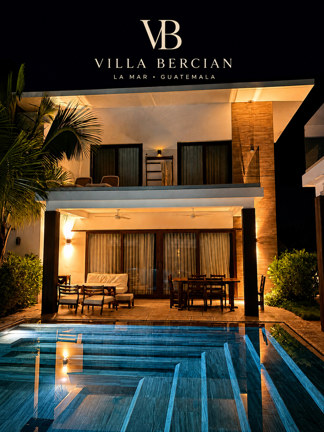 Fachada y piscina de Villa Coral iluminadas durante la noche con el logo oficial de Villa Bercian